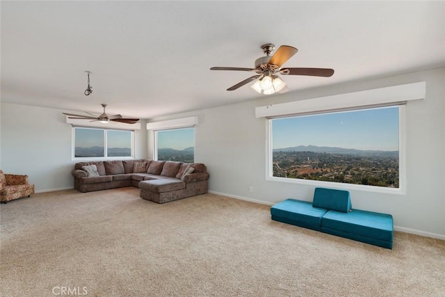 living room featuring carpet, a mountain view, plenty of natural light, and ceiling fan