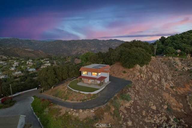 aerial view at dusk featuring a mountain view