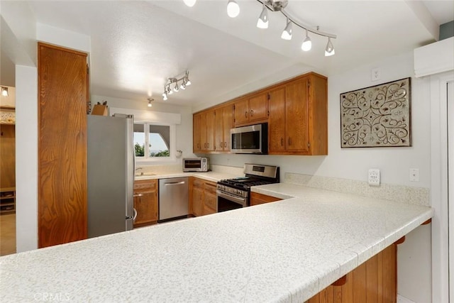 kitchen with kitchen peninsula, appliances with stainless steel finishes, and sink