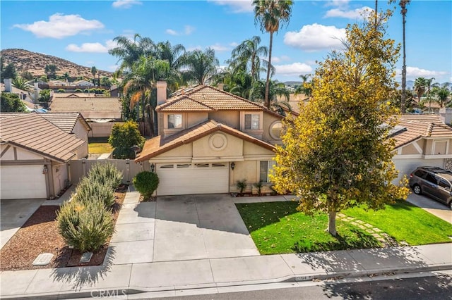 view of front of house featuring a mountain view, a garage, and a front yard