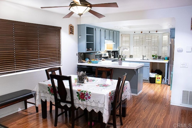 dining room with dark wood-type flooring, ceiling fan, and sink