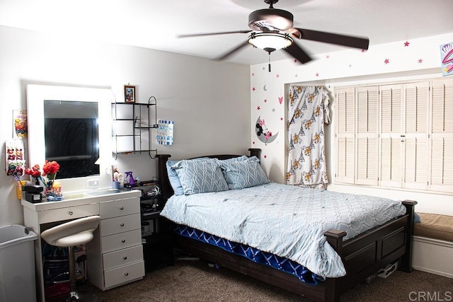 bedroom featuring ceiling fan and dark carpet