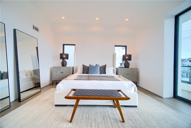 bedroom featuring access to exterior and light hardwood / wood-style flooring