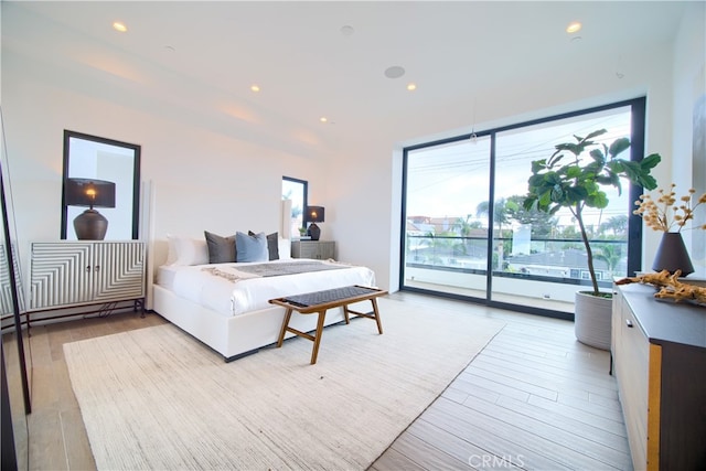 bedroom with access to exterior and light hardwood / wood-style floors