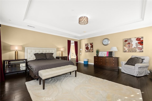 bedroom featuring a raised ceiling, ornamental molding, and hardwood / wood-style floors