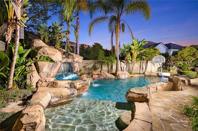 pool at dusk with pool water feature