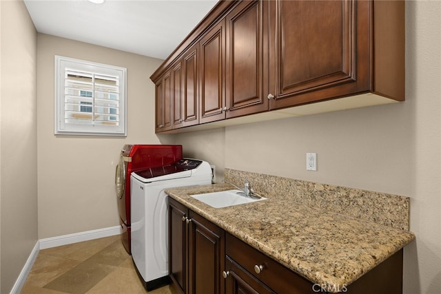 laundry room with sink, washing machine and clothes dryer, and cabinets