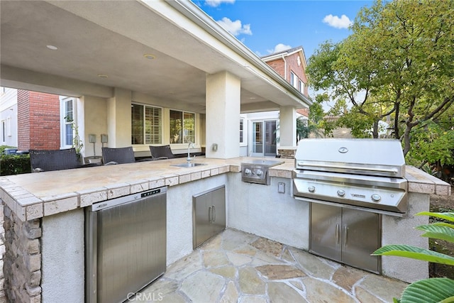 view of patio / terrace featuring an outdoor kitchen, sink, and a grill