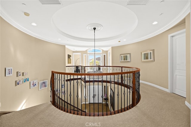 hall with a tray ceiling and carpet