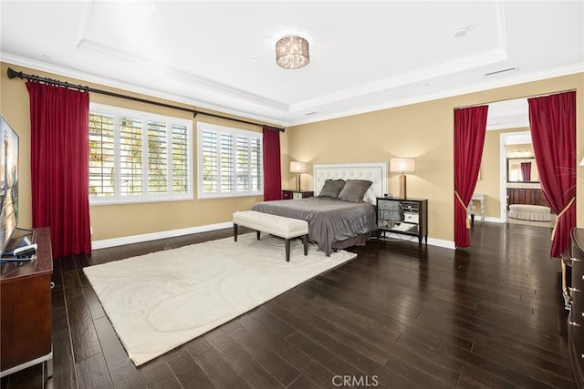 bedroom with ornamental molding, dark wood-type flooring, and a tray ceiling