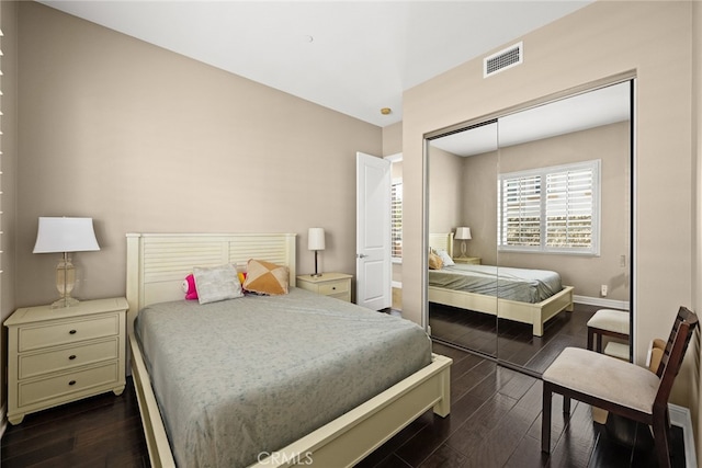 bedroom featuring dark wood-type flooring and a closet