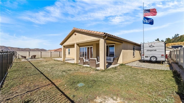 rear view of property with a patio and a lawn