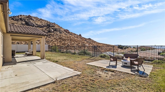 view of yard featuring a patio area, a mountain view, and a fire pit