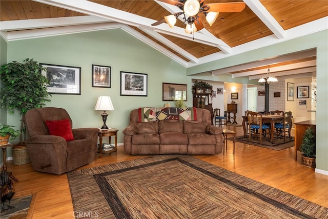 living room with wood ceiling, ceiling fan, vaulted ceiling with beams, light hardwood / wood-style floors, and a wood stove