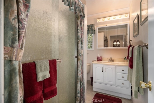 bathroom featuring vanity, crown molding, toilet, and tile patterned flooring