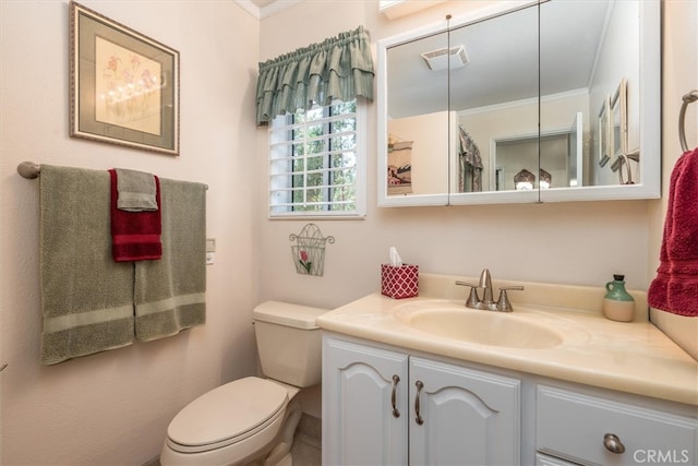 bathroom featuring vanity, crown molding, and toilet