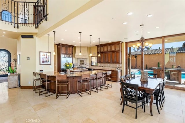 dining space featuring light tile patterned floors, sink, and a chandelier