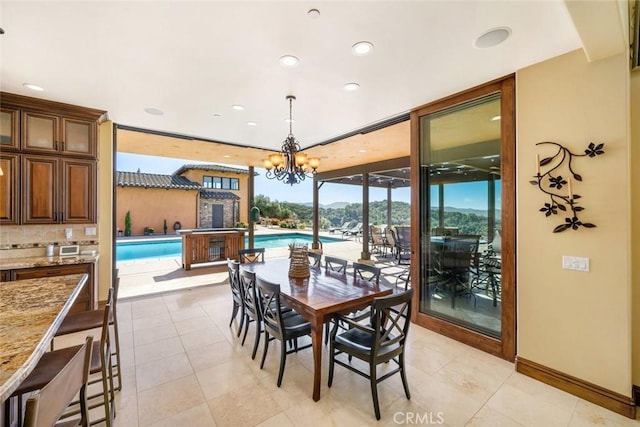 tiled dining area featuring a notable chandelier, a wealth of natural light, and floor to ceiling windows