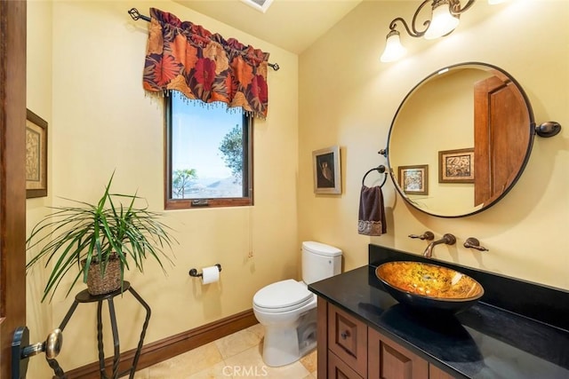 bathroom with toilet, vanity, and tile patterned flooring