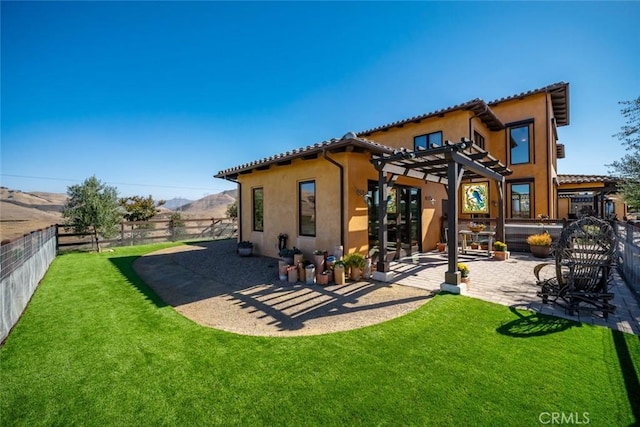 rear view of property featuring a pergola, a patio area, and a yard