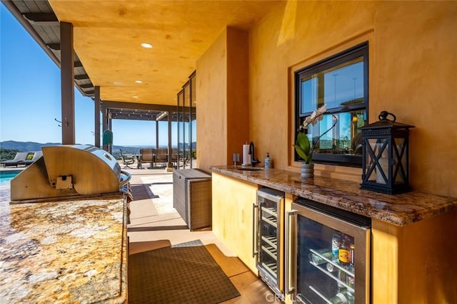 exterior space featuring a mountain view, beverage cooler, and stone counters