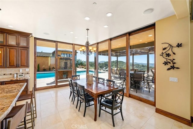 tiled dining space featuring an inviting chandelier and expansive windows