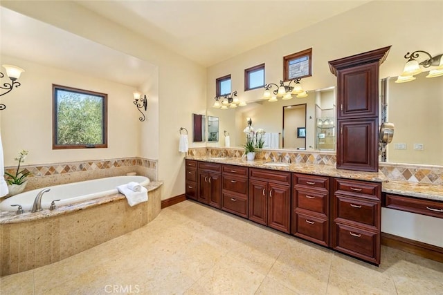 bathroom with tiled bath, vanity, tile patterned flooring, and decorative backsplash