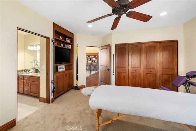 bedroom with ceiling fan, light colored carpet, a closet, and connected bathroom