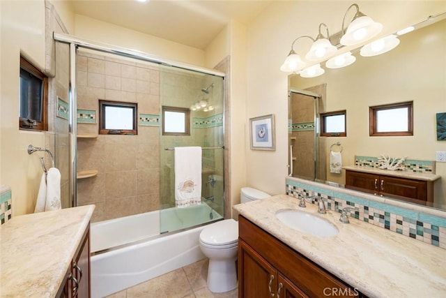 full bathroom with toilet, vanity, backsplash, tile patterned flooring, and enclosed tub / shower combo