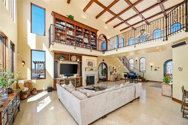 living room featuring light tile patterned floors, beam ceiling, a towering ceiling, and coffered ceiling