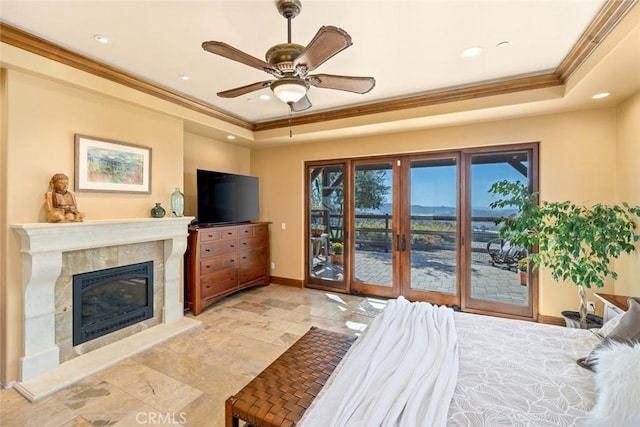 bedroom with ceiling fan, a fireplace, a raised ceiling, and access to outside