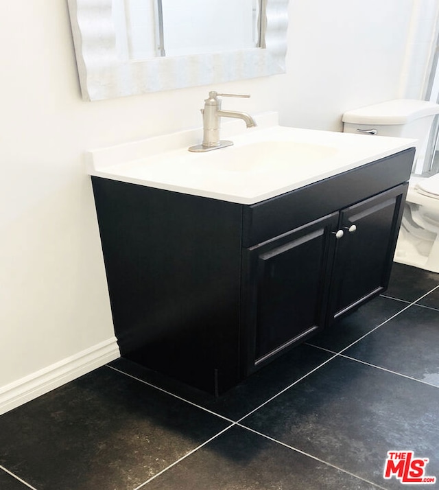 bathroom featuring tile patterned floors, vanity, and toilet