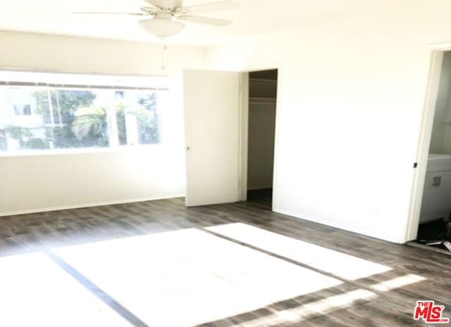 unfurnished bedroom with ceiling fan, a closet, and dark wood-type flooring