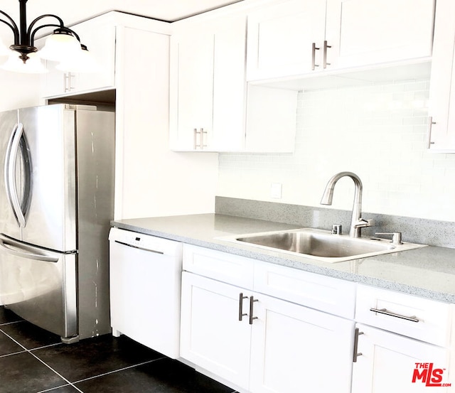 kitchen featuring sink, dark tile patterned flooring, dishwasher, white cabinetry, and stainless steel refrigerator