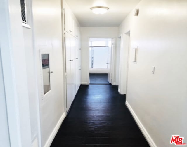 corridor with dark hardwood / wood-style flooring