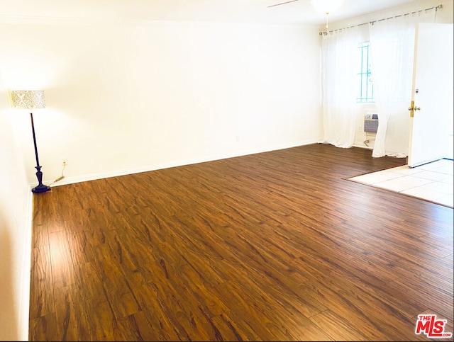 unfurnished room with hardwood / wood-style flooring and crown molding