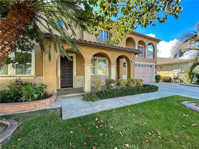 mediterranean / spanish house with covered porch, a front yard, and a garage