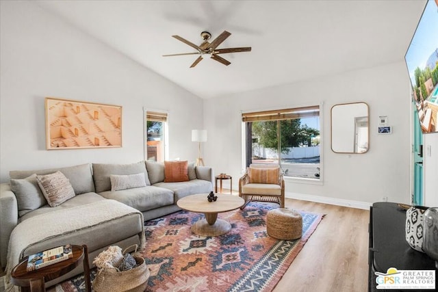 living room featuring ceiling fan, light hardwood / wood-style floors, and vaulted ceiling