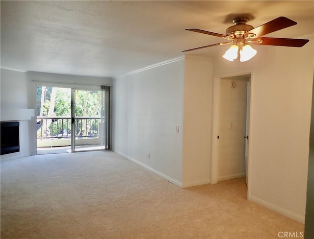 unfurnished living room featuring ceiling fan, crown molding, and light carpet