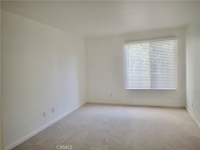 unfurnished room featuring light carpet