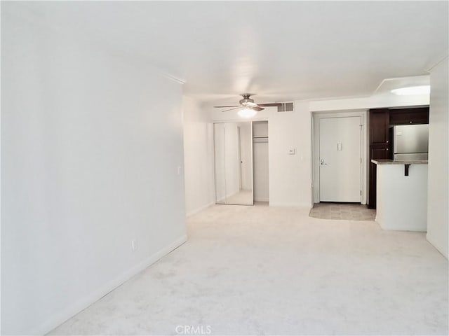 empty room featuring ceiling fan and light colored carpet