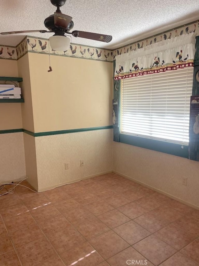 spare room featuring a textured ceiling and ceiling fan