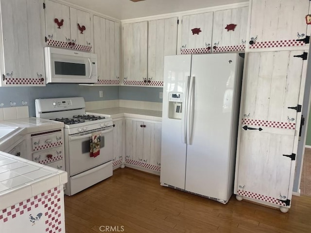 kitchen with white appliances, tile countertops, and dark wood-type flooring