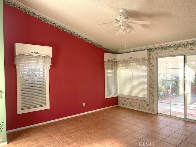 empty room with a textured ceiling, ceiling fan, crown molding, and tile patterned floors