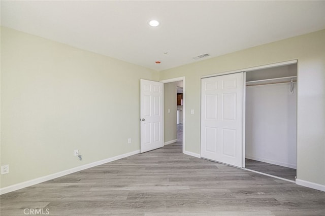 unfurnished bedroom featuring a closet and light hardwood / wood-style flooring