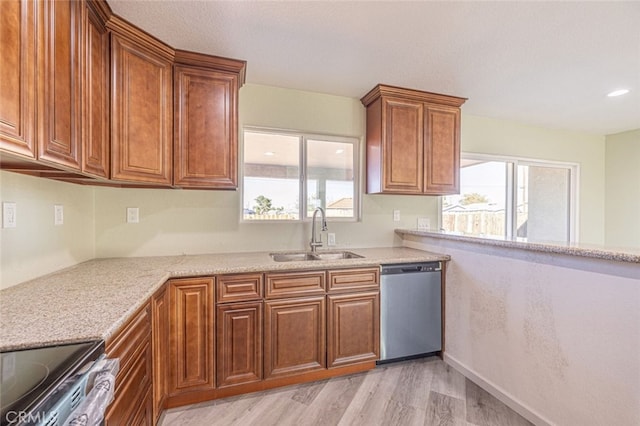 kitchen featuring light stone countertops, sink, stainless steel appliances, and light hardwood / wood-style floors