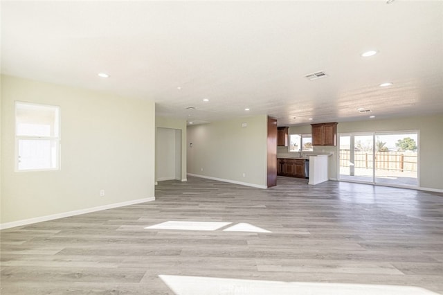 unfurnished living room featuring sink and light hardwood / wood-style flooring