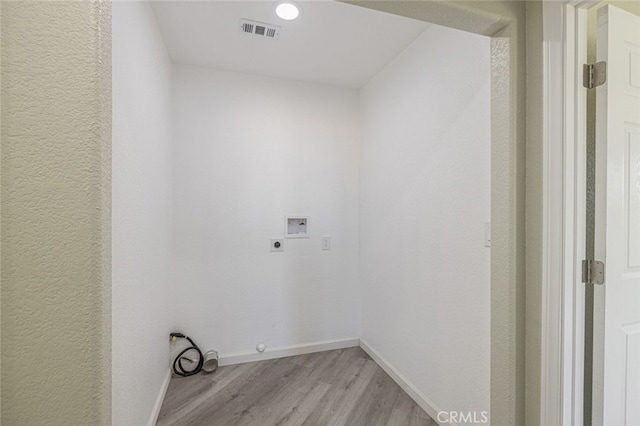 laundry room with hookup for an electric dryer, hookup for a washing machine, light hardwood / wood-style floors, and hookup for a gas dryer