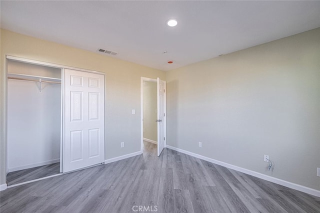 unfurnished bedroom with wood-type flooring and a closet