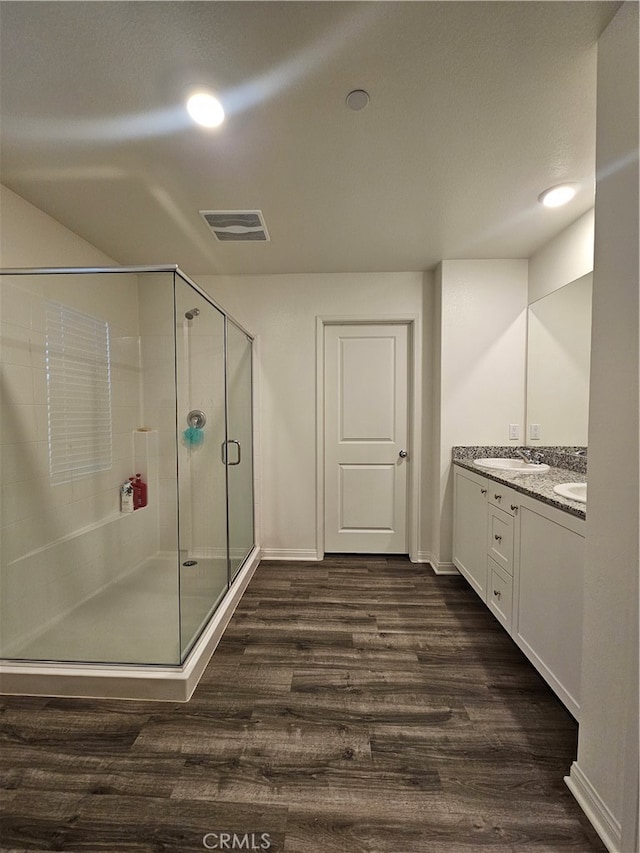 bathroom with a shower with door, vanity, and hardwood / wood-style flooring